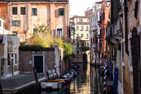 Italy. The cityscape and architecture of Venice. Urban canal and boats on itのeditorial素材