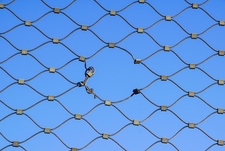 Metal wire fence protection chainlink background . holeの写真素材