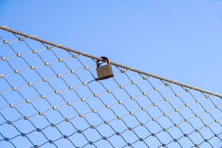 close up a key lock hook on iron wire gates and water drop of rain with blur background,selective focusの写真素材