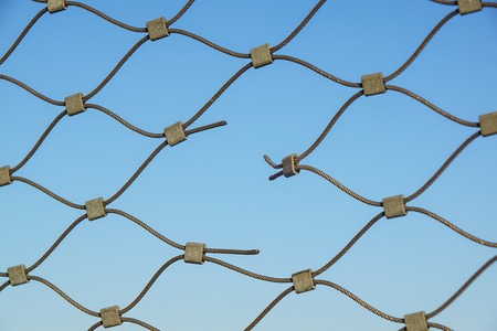 Metal wire fence protection chainlink background . holeの写真素材