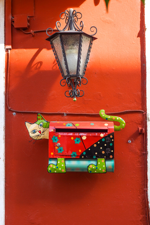 mailbox metal made in shape of a cat, on red wallの写真素材