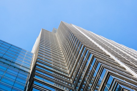 Perspective and underside angle view to textured background of contemporary glass building...