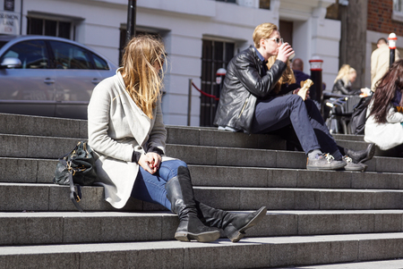 LONDON, UK - APRIL 22, 2017: People are sitting on the steps of the squareのeditorial素材