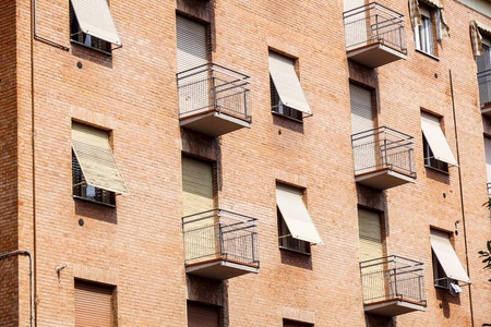 Exterior of old brick urban housing block with apartments and balconyの写真素材