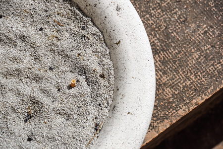 Cigarette butt with ash in the ashtray .の写真素材