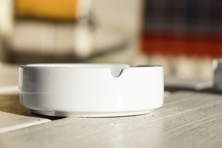 White ceramic ashtray on a wooden backgroundの写真素材