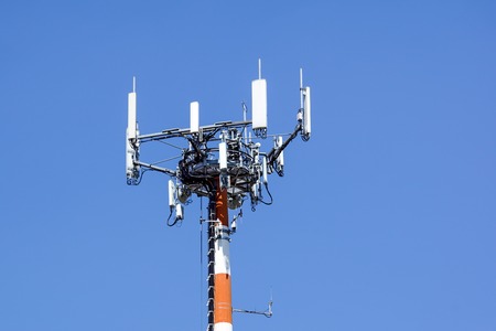 Antenna tower, with the blue sky. Close-up of the Communication antenna building with the sky background.の写真素材