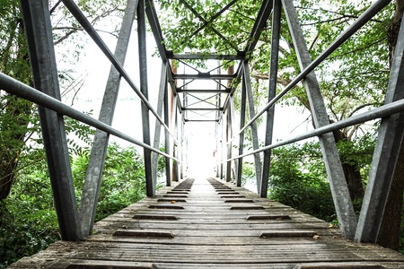 Wood and metal footbridge on the river in autumnの写真素材