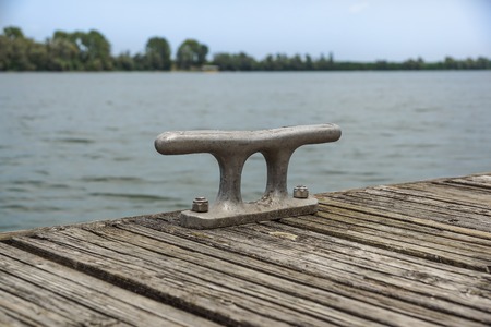 Worn old rusty mooring bollard on the river dockの写真素材