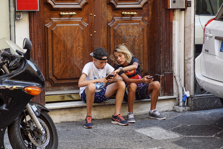 NICE , FRANCE 15 AUGUST 2017 : undefined Teenager with Cellphone on the landing steps of the Houseのeditorial素材