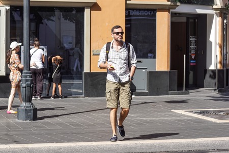 Nice , France 15 August 2017 : A man listening music while walking on street in Nice center villeのeditorial素材