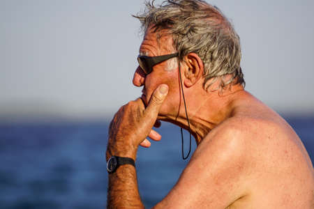 Nice , France - 5 august 2017 : Serious man sreflects looking at the horizon on the beach. Close-up portraitのeditorial素材