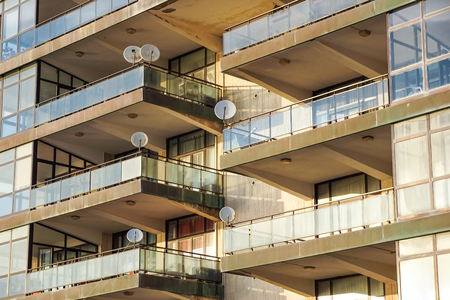 Facade of the reseidential building with windows and balconies and satelite antennasの写真素材