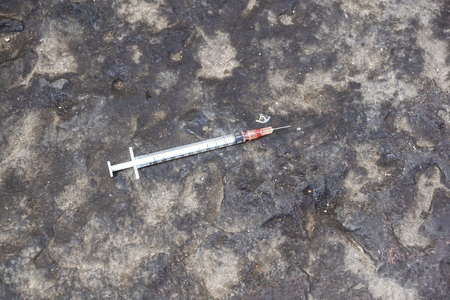 substance abuse, addiction and drug use concept - close up of used syringes on ground .の写真素材