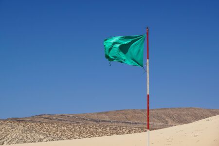Green flag on the beach. suny day vacation seascape.の写真素材