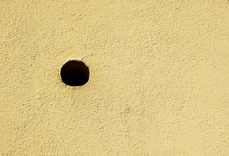 black hole in in white wall as a backgroundの写真素材