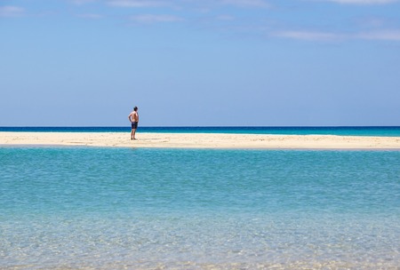 Freedom and happiness. Man rising hands up on the sea beach.の写真素材