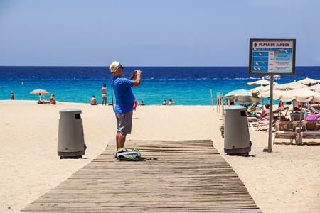 Fuerteventura , Spain 13 june 2017 : Man takes pictures on the beach of the Canary Islandsのeditorial素材