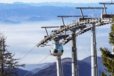 Ski lift cable booth or car, Ropeway and cableway transport sistem for skiers with fog on valley backgroundの写真素材