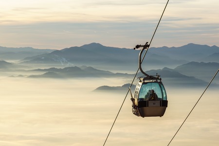 Ski lift cable booth or car, Ropeway and cableway transport sistem for skiers with fog on valley backgroundの写真素材