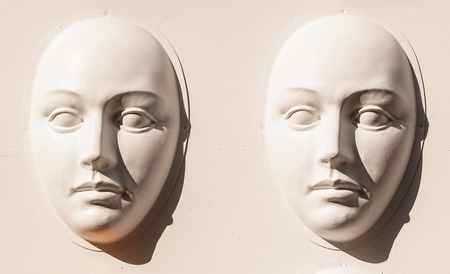 Carnival masks hanging on wall boards lie on floorの写真素材