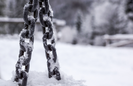 Anchor chain detail in hoarfrost in winter sunny day with selective focus