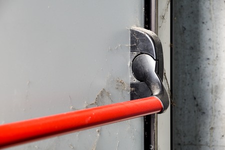 Closed up latch and door handle of emergency exit. Push bar and rail for panic exit.の写真素材