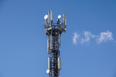 Telecommunication tower with antennas with blue sky .