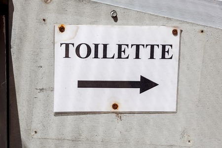 toilet sign on cement wall . close up