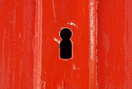 Detail of old wooden red painted door with heart shaped key holeの写真素材