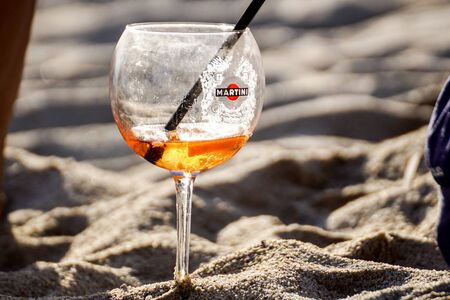 Riccione , Italy - May 1, 2018: A bottle of Martini champagne, sea beach on the background.Three refreshing summer cocktails at a beach bar. Selective focusのeditorial素材