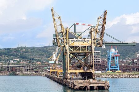 Livorno, Italy - August 27, 2018: Shipping industrial trade port. Crane bridge and import export container at shipping port harbor.のeditorial素材