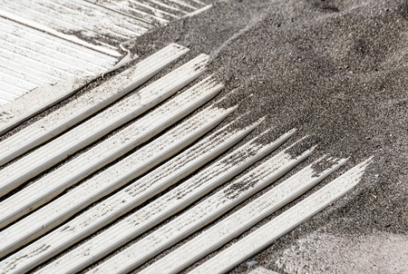 Top view of wooden beach boardwalk with sand texture backgroundの写真素材