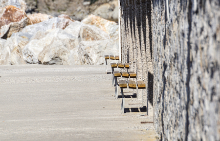 Wooden bench in a room with concrete floor and concrete wallの写真素材