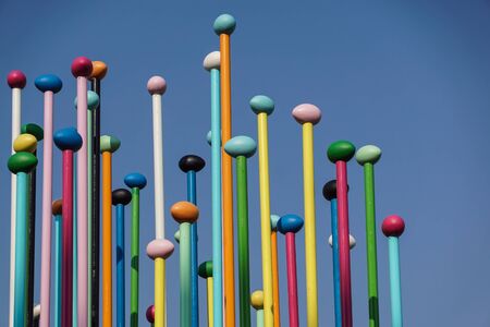 Low angle of colorful thin poles against blue sky. Positive and bright background concept .の写真素材