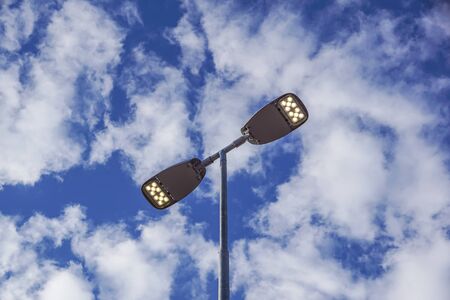 Three LED Street Lamps Affixed to an Iron Post Against a Deep Blue Sky