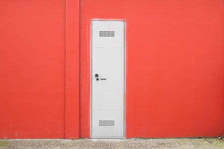 Cement concrete wall texture with modern red doorの写真素材