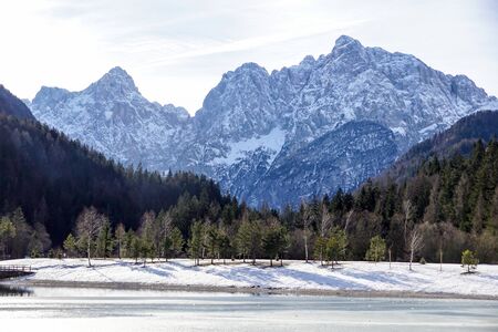 Winter landscape Bled Lake. Travel Slovenia, Europe. Bled Lake one of most amazing tourist attractions. View on snowy Island with Catholic Church in Bled Lake with Castle and Alps in Backgroundの写真素材