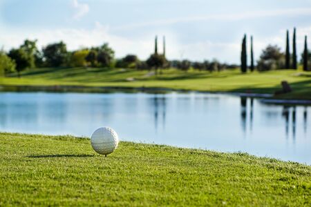 Golf ball on the green with warm tone and sunset,の写真素材