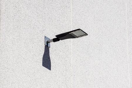 LED fixed on to a bend lamp post in front of a building. The lamp post