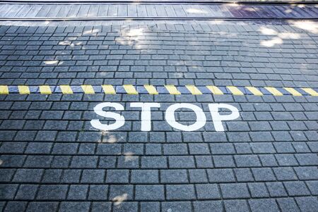 Stop written on floor asphalt concept image