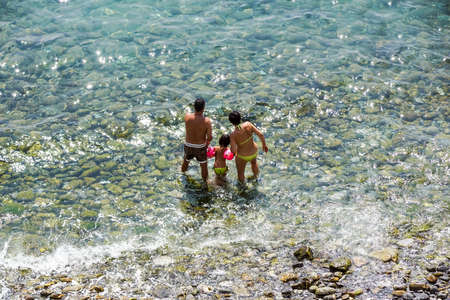 RIMINI , Italy 16-08-20 : Family of four having fun on tropical beachのeditorial素材