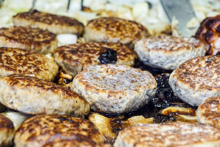 An hamburgher is cooking in a hot barbeque