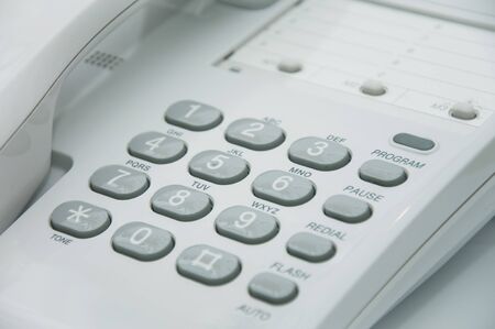 Close up image of a white plastic telephone deviceの写真素材
