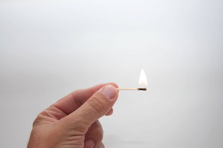 Male hand with a burning matchの写真素材