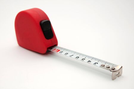 Red tape measure meter over a white backgroundの写真素材