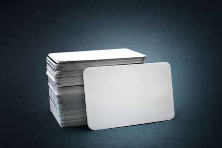The pile of blank business cards lays propped up another business card.の写真素材