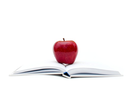 red organic apple placed on the top of the white booksの写真素材