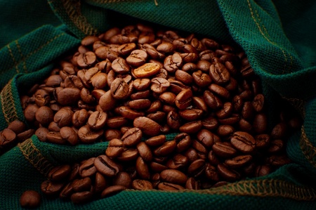 Beautiful brown coffee beans in a green bag, close up imageの写真素材