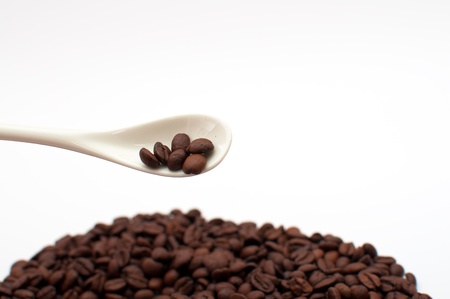 Beautiful brown coffee beans and a spoon, close up imageの写真素材